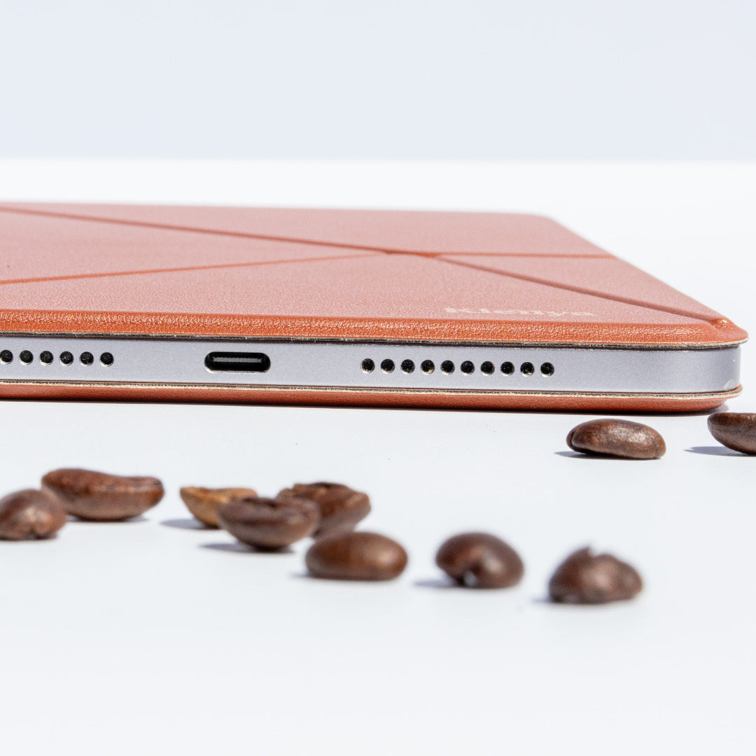 Close-up of a brown iPad case with coffee beans on a white background